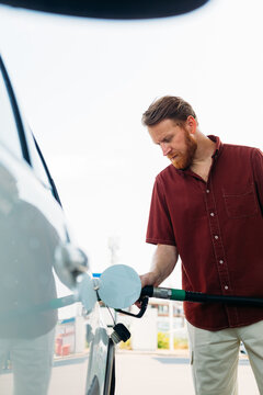 Man Refilling Car Tank with Petrol 