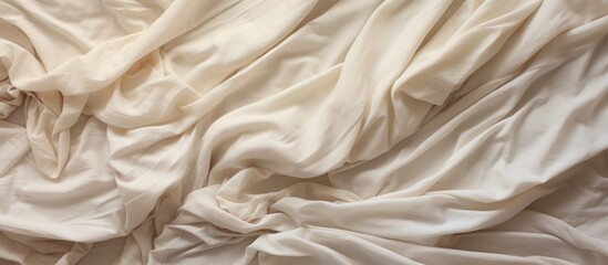 This top view photo shows an unmade bed with a crumpled white comforter. The bedding is disheveled, giving a casual and lived-in appearance.
