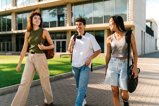 Happy university students walking down the street