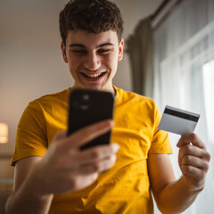 teenager young man at home use credit card shopping online