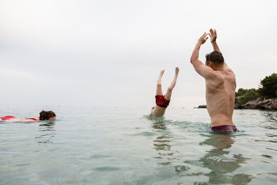 Man throws his child in the sea water