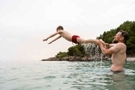 Father throws his little son in the sea water