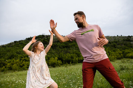 Dad and daughter practicing wrestling techniques
