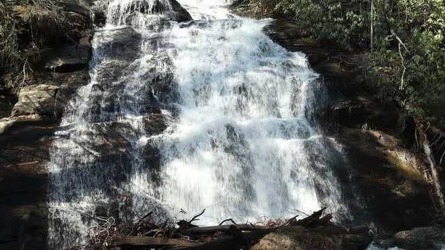slow motion footage of the rushing waters of Smith Creek and waterfall at Anna Ruby Falls with rocks and lush green trees and plants in Helen Georgia USA