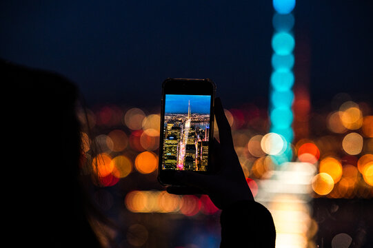 Woman taking photo of night city