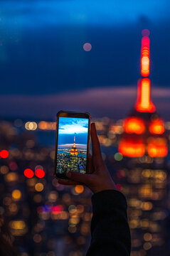 Woman taking photo of night city
