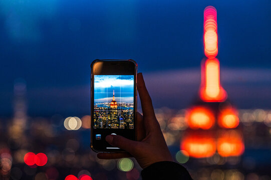 Woman taking photo of night city