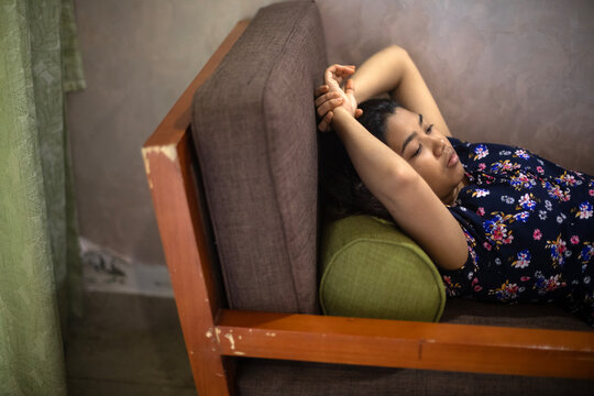 Teenage Indian girl relaxing and taking rest inside a house