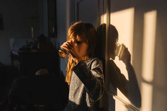 A girl with a glass of water in the evening