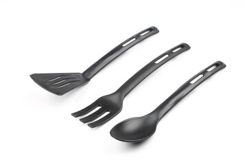 Black plastic kitchen spatula and spoon isolated on white background