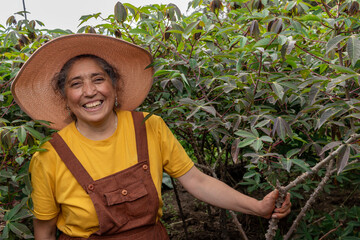 Empowered female farmer with a big smile working in a yuca plantation