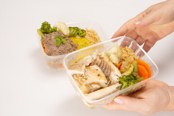 Hands serving packed lunch box home prepared meal in aerial top view close up empty space isolated