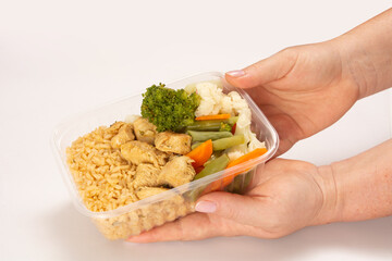 Hands serving packed lunch box home prepared meal in aerial top view close up empty space isolated
