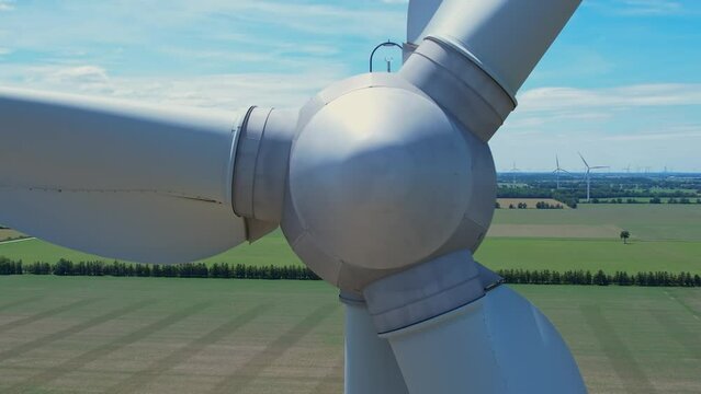 Close up shot of wind mills turbine rotation by the wind and generating renewable green sustainable energy. Energy alternative and environment ecology. Closeup of a wind turbine in the farmers field.