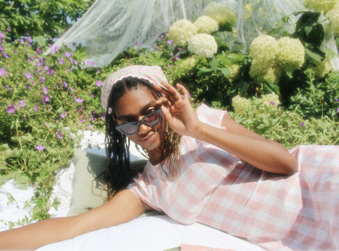 Girl with Books and Sunglasses in Garden