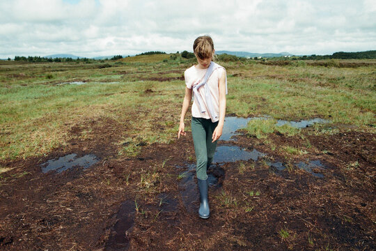 A girl walking outdoors in muddle puddles