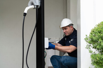 Qualified technician install home EV charging station, providing maintenance service for electric...