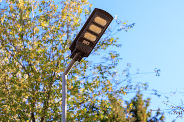 A street light is lit up in the daytime