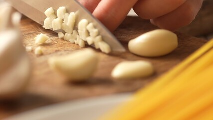 Diced garlic on a chopping board. Fried Assassin's Spaghetti Cooking Step. Close-up, shallow dof.