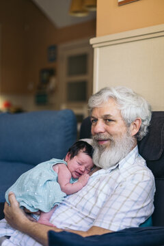 Newborn taking a nap with her grandfather