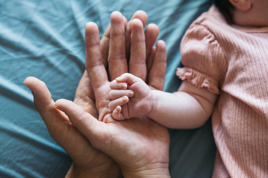 Hands Of A Newborn Baby and her parents