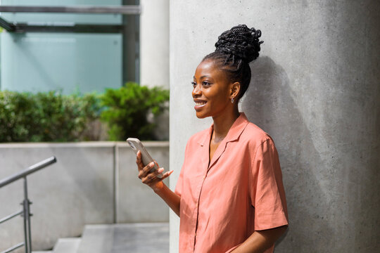 A Woman Uses A Mobile Phone Standing Outdoors