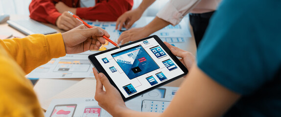 Panorama banner of startup UX developer or company employee design user interface or UI prototype for mobile application or website software with software display on tablet screen in office. Synergic