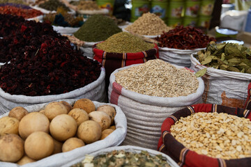 Variety organic groats in sacks on sale on a farmers market, ecological oatmeal, hibiscus, herbs. Traditional arabic market.