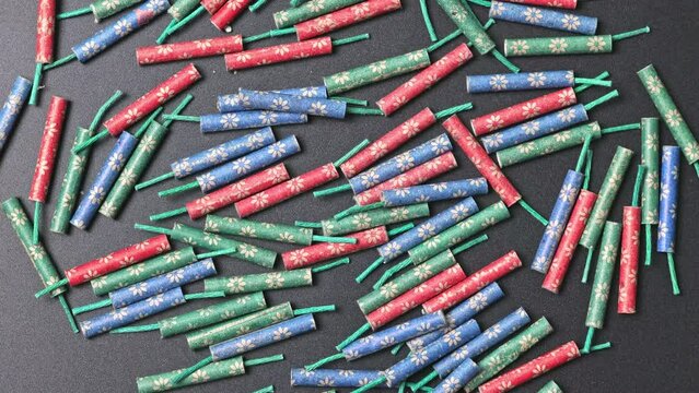 Small firecrackers of different colors on a black background rotate slowly.