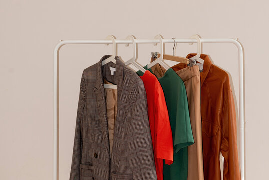 Clothes in warm tones hanging in row