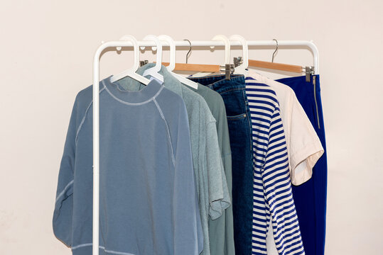 Clothes in blue tones hanging in row