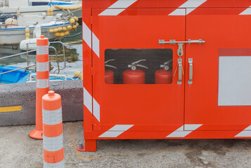 Red cabinet in the harbor where fire extinguishers are stored.