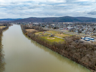 Sayre, PA, USA - 03-03-2024 - Cloudy winter aerial image of Chemung River near downtown area in the...