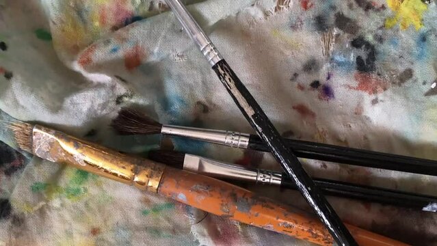 the artist's brushes are thrown onto the canvas, close-up, zoom in