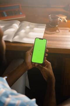 A man with a green-screen phone in the office