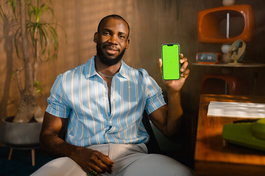 A man with a green-screen phone in the office