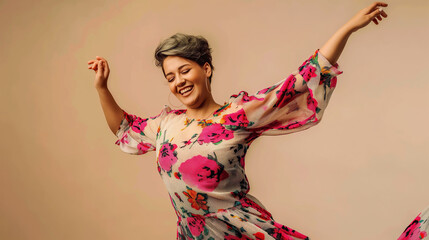A devoted mid aged short hair happy woman in floral dress dancing isolated on beige background with copy space, concept of hobby, enjoy happiness lifestyle.