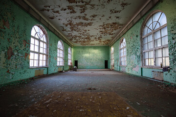 Fototapeta na wymiar Large hall of abandoned building with peeled paint
