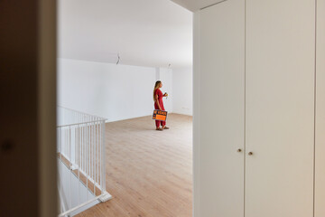 Concentrated woman standing in empty room with sign board