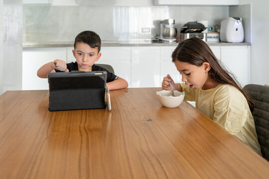 Kids Glued to Laptop Screen in Cozy Living Room Setting at Home.