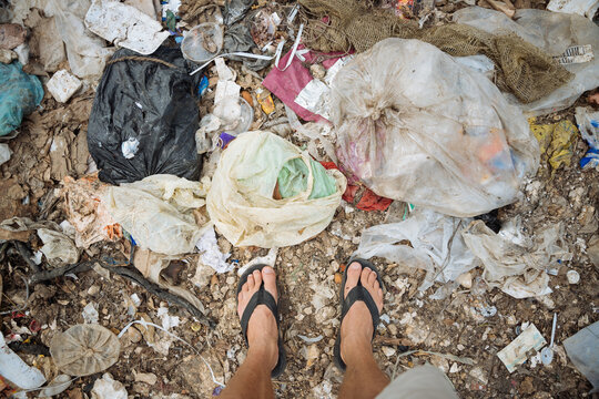 pov of male feet in trash dump