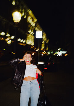 Happy tipsy woman at night on the street 