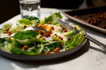 Green lettuce with crispy chick peas and a sunny side up fried egg. 