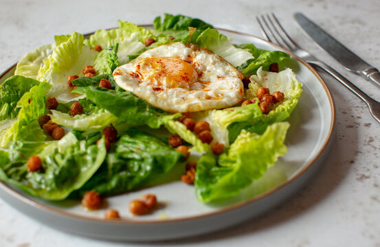 Green salad with spiced crispy chick peas and an olive oil fried egg. 
