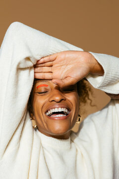 Excited woman with cosmetic mask on face smiling on studio photo
