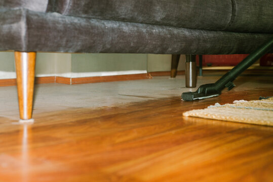 Vacuum cleaner and a large amount of dust under the couch 