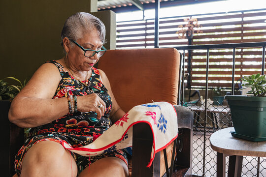 Grandmother embroidering on fabric. 
