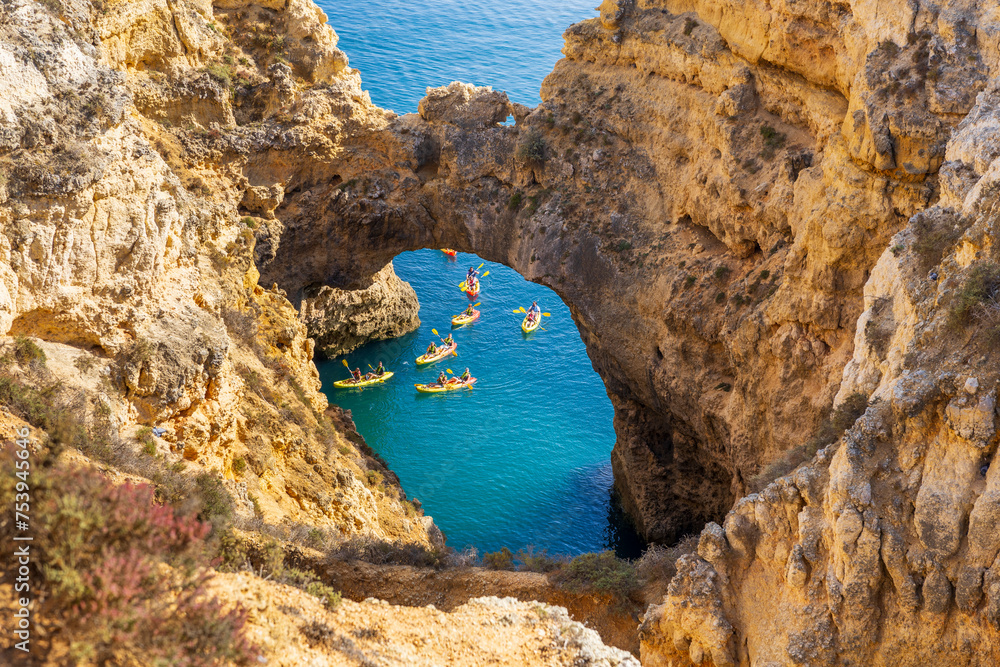 Wall mural kayakers in the cathedral arch natural landmark in the atlantic ocean at ponta da piedade, algarve c