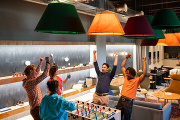 People Playing Foosball Game At Co-working
