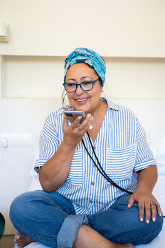 A Woman Is sending audio message On Her Mobile At Bedroom 